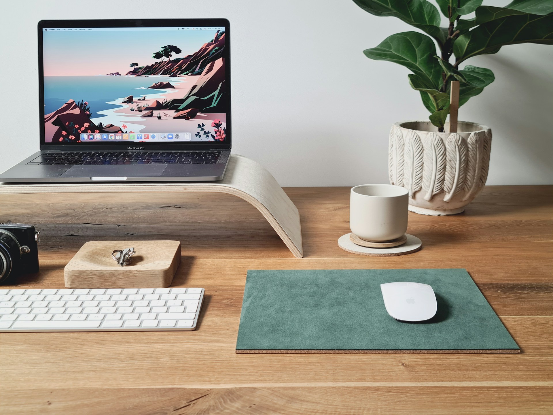 Image of a laptop on a desk with a mouse, keyboard and plant
